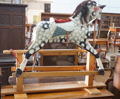 A vintage Ayres type dapple grey carved wood rocking horse on beech safety frame, length 130cm, height 115cm